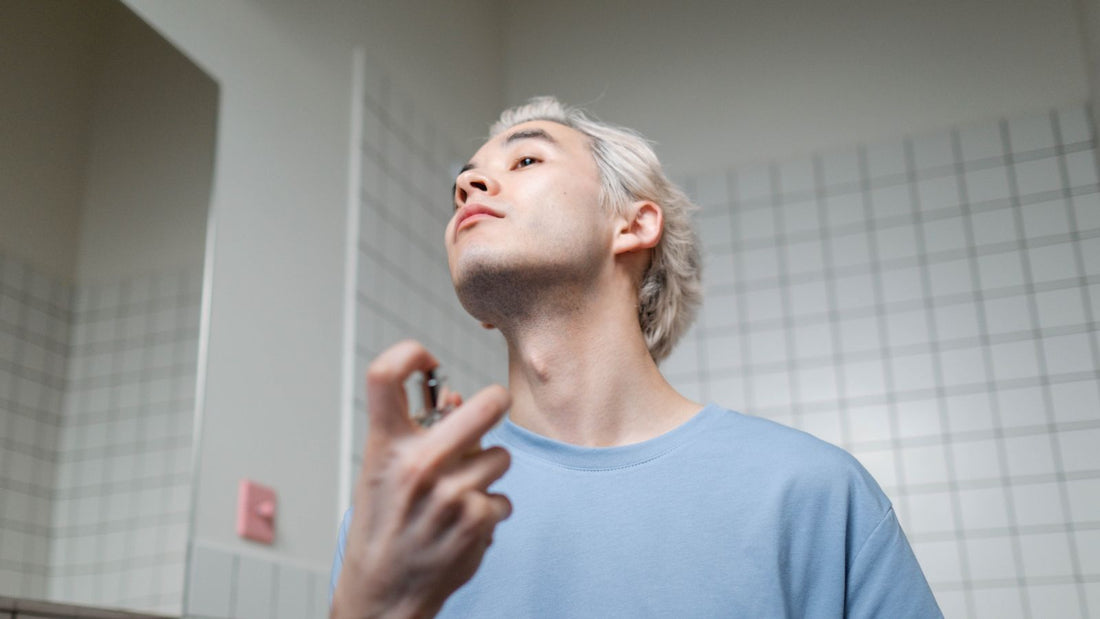 Ein Mann trägt bei seiner Morgenroutine Parfüm auf